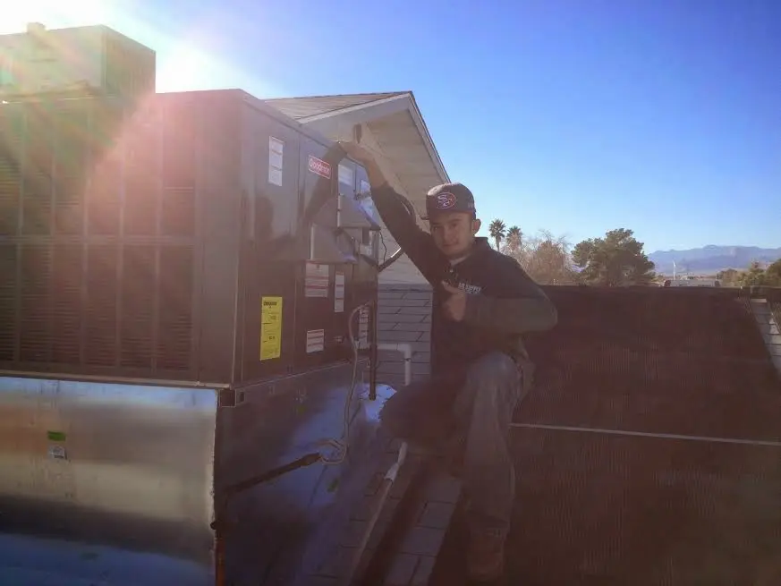 HVAC technician performing AC Tune-Up on a rooftop unit in St. Matthews
